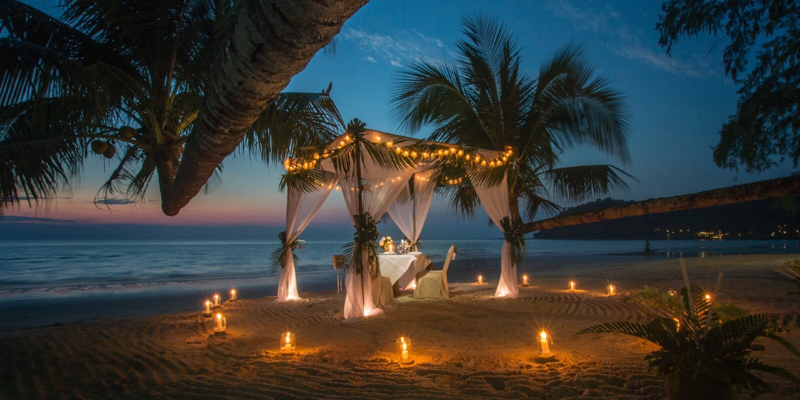 Romantic evening on the beach in a candle-lit cabana.